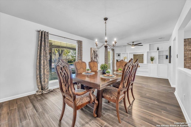 dining area with ceiling fan with notable chandelier, hardwood / wood-style floors, and built in shelves