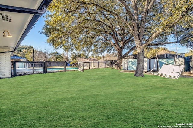 view of yard with a fenced in pool and a shed