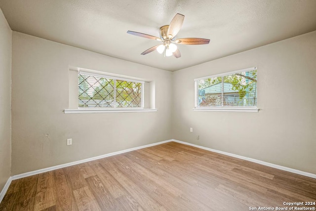 spare room with ceiling fan and light wood-type flooring