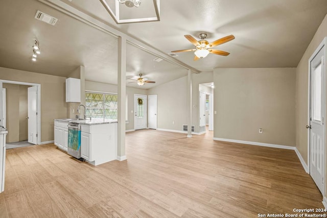 kitchen with light stone counters, dishwasher, light hardwood / wood-style floors, white cabinetry, and lofted ceiling