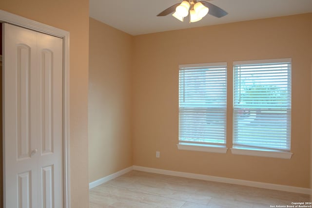 tiled spare room featuring ceiling fan