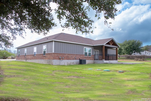 view of front facade featuring a front yard and central air condition unit