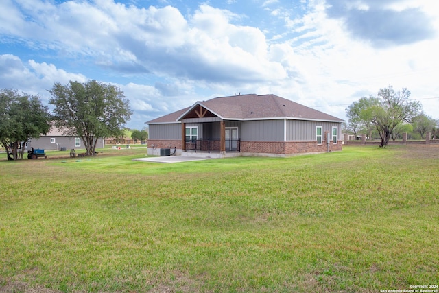 rear view of property with a lawn