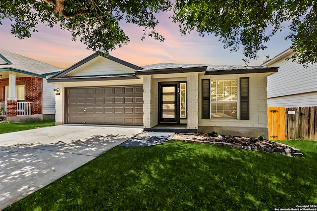 view of front of house featuring a garage and a lawn