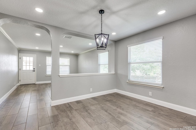 interior space with crown molding, hardwood / wood-style floors, and a notable chandelier