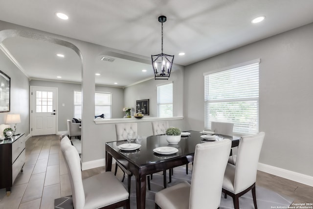 dining room with ornamental molding and a notable chandelier