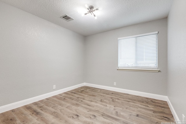 empty room featuring light hardwood / wood-style flooring and a textured ceiling