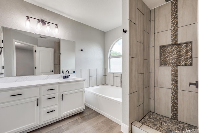 bathroom with vanity and independent shower and bath