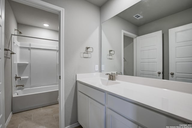 bathroom with washtub / shower combination, vanity, and tile patterned floors