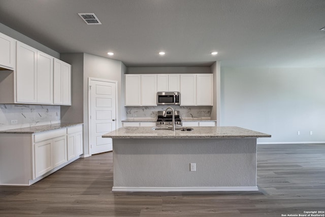 kitchen featuring white cabinets, a center island with sink, and appliances with stainless steel finishes