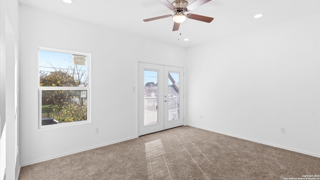 spare room featuring ceiling fan, light carpet, and french doors