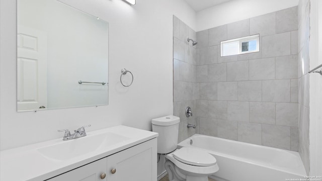 full bathroom with toilet, vanity, and tiled shower / bath