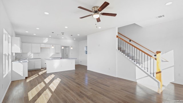 kitchen featuring white cabinets, dark hardwood / wood-style flooring, a kitchen island, and ceiling fan