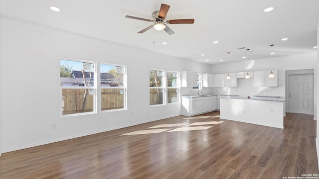 unfurnished living room featuring ceiling fan and dark hardwood / wood-style floors