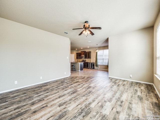 unfurnished living room with light wood-type flooring and ceiling fan