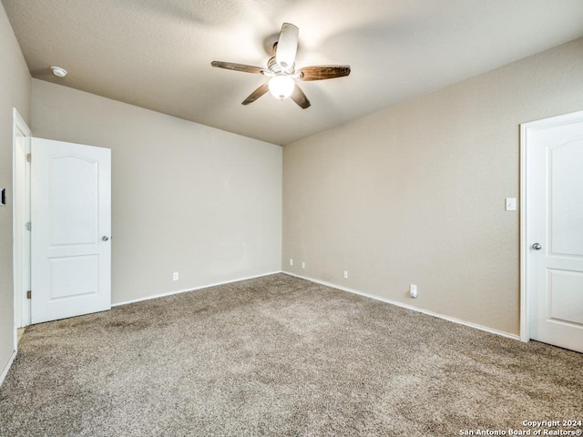 carpeted spare room featuring ceiling fan