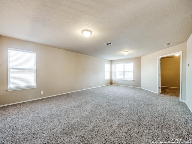 spare room featuring carpet flooring and a textured ceiling