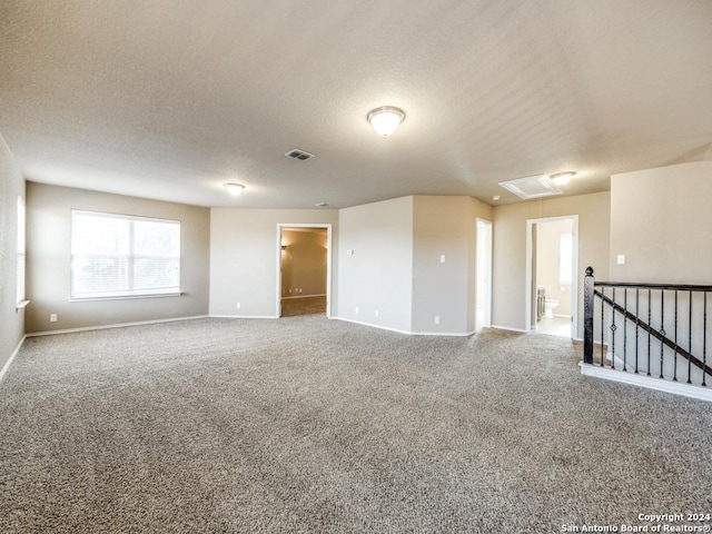 unfurnished room with carpet flooring and a textured ceiling