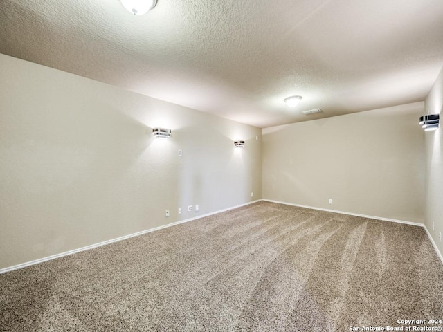 spare room featuring a textured ceiling and carpet floors