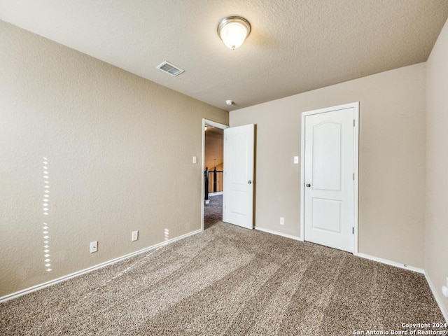 unfurnished bedroom with carpet flooring and a textured ceiling