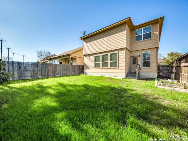 rear view of house featuring a yard