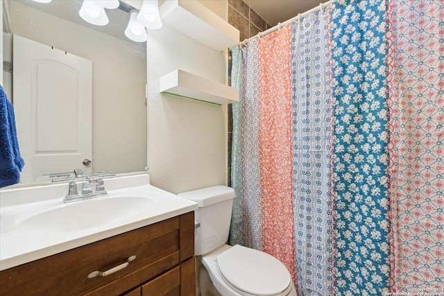 bathroom featuring vanity, toilet, and walk in shower