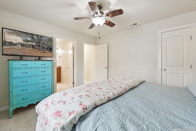 bedroom with ensuite bathroom, ceiling fan, and light carpet