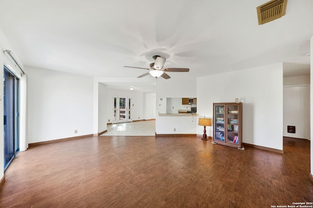 unfurnished living room featuring plenty of natural light, ceiling fan, and wood-type flooring