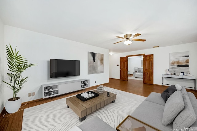 living room with wood-type flooring and ceiling fan