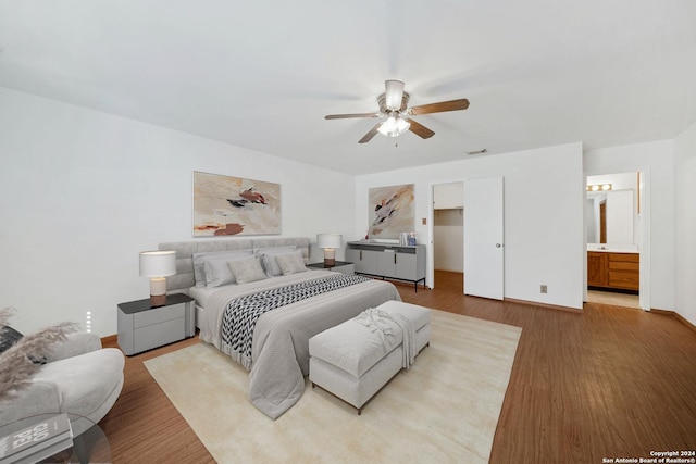 bedroom with connected bathroom, ceiling fan, and wood-type flooring