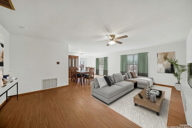 living room featuring ceiling fan and light hardwood / wood-style floors