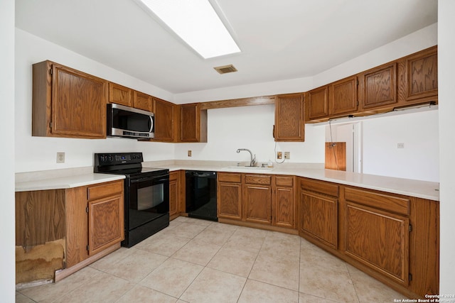 kitchen with light tile patterned flooring, sink, and black appliances