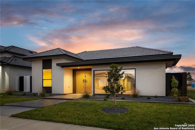 prairie-style home featuring a lawn