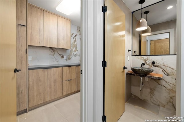 bathroom with tile patterned flooring, decorative backsplash, and sink