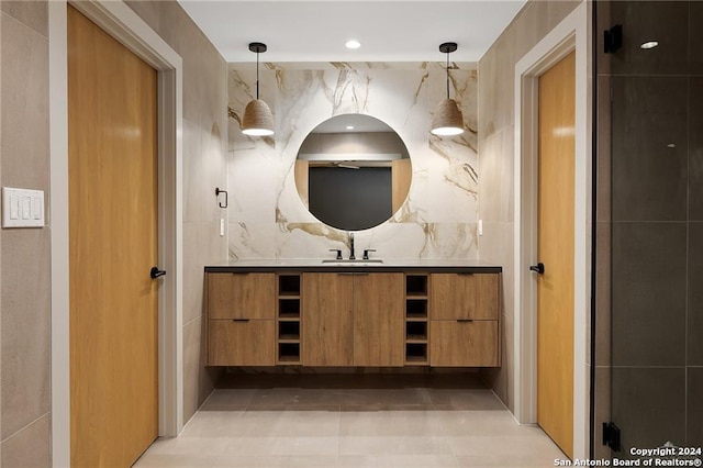 bathroom with tile patterned flooring, vanity, tasteful backsplash, and tile walls