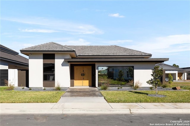 prairie-style home featuring a front lawn