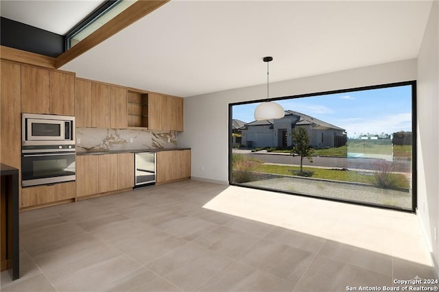 kitchen with beverage cooler, tasteful backsplash, decorative light fixtures, light tile patterned floors, and appliances with stainless steel finishes