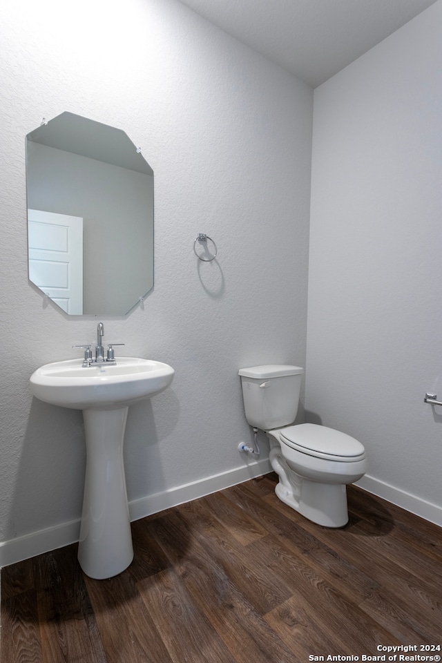 bathroom with toilet and wood-type flooring