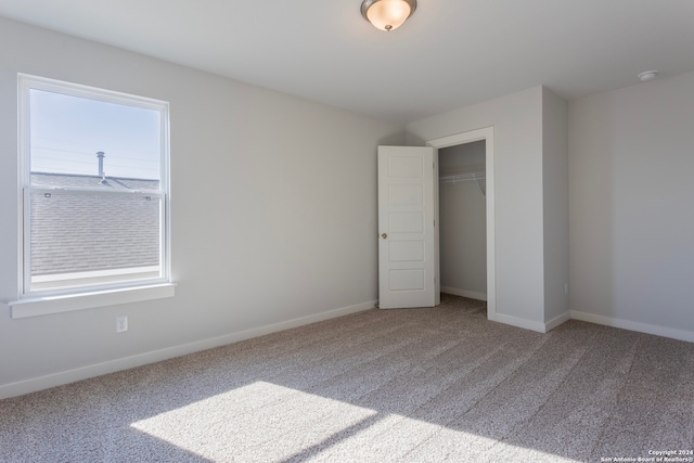 unfurnished bedroom with multiple windows, carpet floors, and a closet