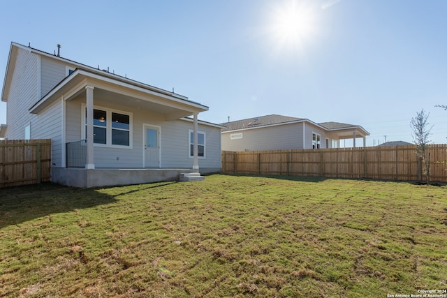 rear view of house featuring a yard