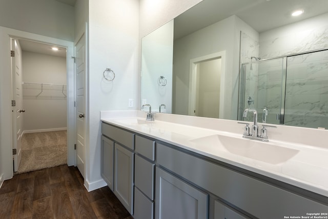 bathroom with hardwood / wood-style floors, vanity, and an enclosed shower