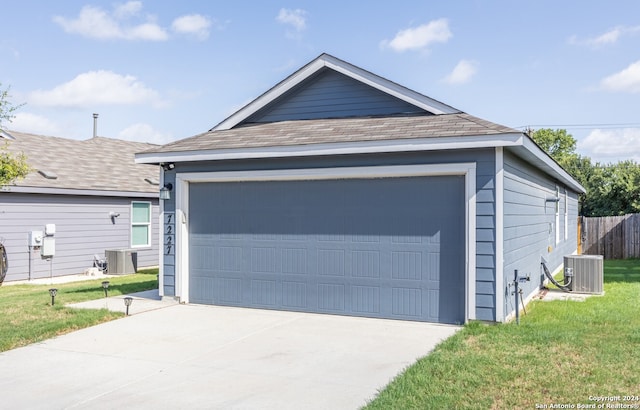 garage featuring a yard and central AC unit