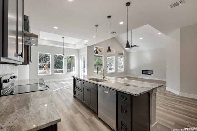 kitchen with pendant lighting, dishwasher, sink, and an island with sink