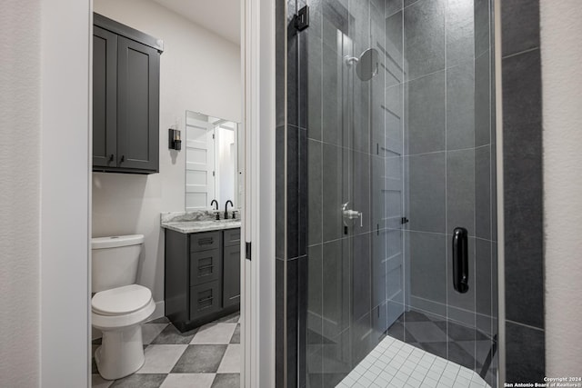 bathroom with vanity, toilet, and a shower with door