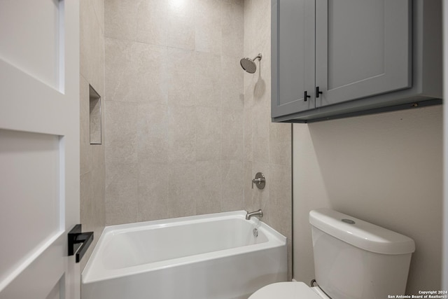 bathroom with tiled shower / bath combo and toilet