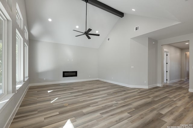 unfurnished living room with beam ceiling, ceiling fan, hardwood / wood-style floors, and high vaulted ceiling