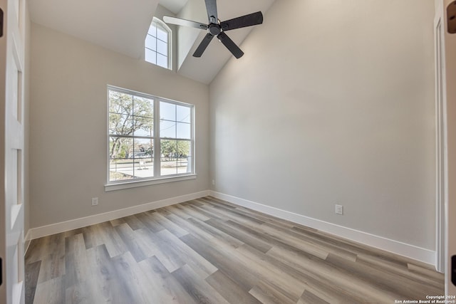 empty room featuring ceiling fan, light hardwood / wood-style flooring, and high vaulted ceiling