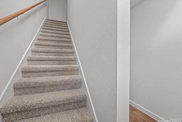 staircase with hardwood / wood-style flooring