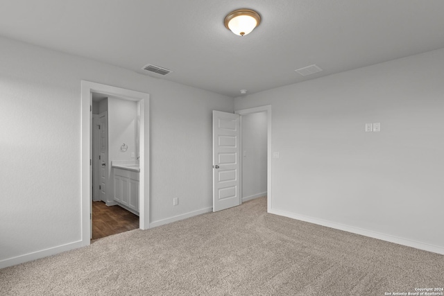 unfurnished bedroom featuring carpet flooring and ensuite bath