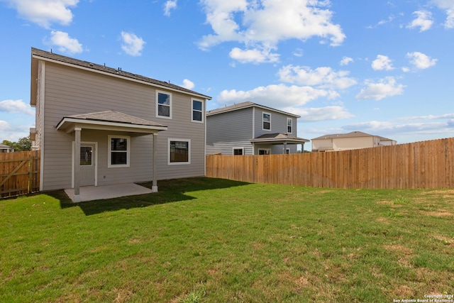 rear view of property with a lawn and a patio area